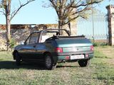 a car that is parked in the grass near a fence