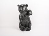 une statue d'ours noir assis sur ses pattes arrière