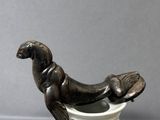 une statue représentant un phoque assis sur une tasse