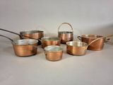 an image of a group of copper pots and pans on a table