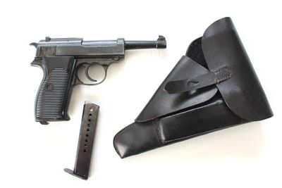 un pistolet, un étui et un chargeur posés sur une surface blanche