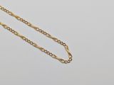 a close up of a gold chain on a white surface