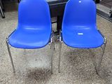 deux chaises bleues placées l'une à côté de l'autre dans une pièce