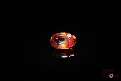 un gros plan d'un saphir orange sur une surface noire