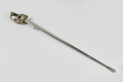an old sword with a metal handle on a white surface