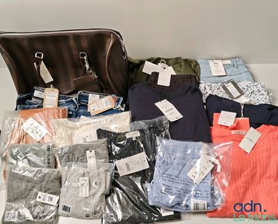 beaucoup de vêtements et un sac à main posés sur une table