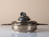a silver bowl with a dog on it sitting on a table