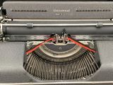 an old typewriter sitting on a table with a metal case