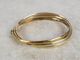 a close up of a gold bang bracelet on a marble surface