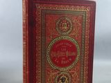 un vieux livre à la couverture rouge et aux bordures dorées