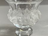 un vase en verre transparent contenant des fleurs, posé sur une table