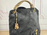 un sac à main noir et doré posé sur une table en bois