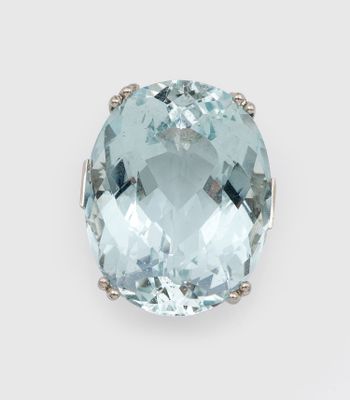 une pierre ovale de couleur aigue-marine sertie dans une bague en or blanc