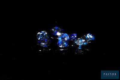 a close up of a group of blue crystals on a black surface
