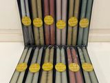 a box of 12 different colored candles sitting on top of each other