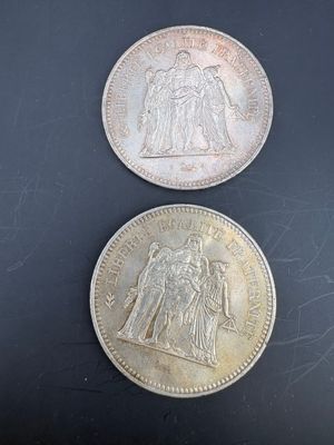two silver coins sitting on top of each other on a table