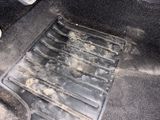 a dirty floor in a car with a dirty floor mat