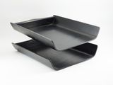 two black plastic trays stacked on top of each other on a white surface