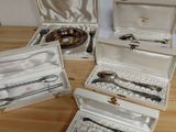 five silverware items in a case on a wooden table
