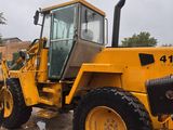 a yellow tractor that is parked in the dirt