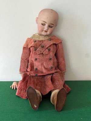 a doll that is sitting on a green surface