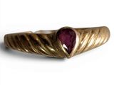an image of a close up of a gold ring with a ruby stone