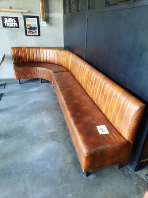 un banc en cuir marron dans un coin de la pièce