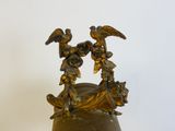 a vase with a bird on top of it on a table
