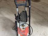 un nettoyeur haute pression posé par terre dans un garage