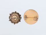an image of a pair of gold colored buttons on a white surface