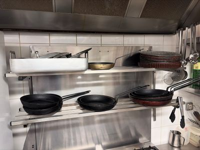 many pots and pans on the shelves in the kitchen