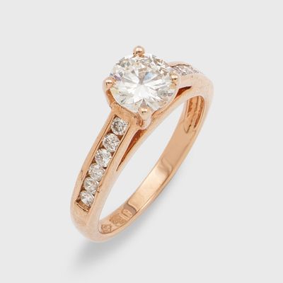une bague de fiançailles en or rose sertie d'un diamant rond taille brillant