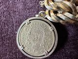 a silver coin on a chain with a chain around it