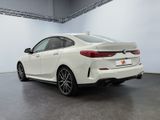 the rear end of a white bmw car parked in a garage