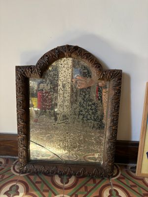a mirror sitting on a table next to a picture frame