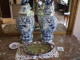 deux vases bleus et blancs posés sur une table devant un miroir
