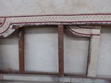 a wooden bench with a red and white design on it