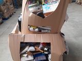 a cardboard cart with many items in it in a warehouse
