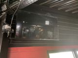 a television mounted on the ceiling of a restaurant