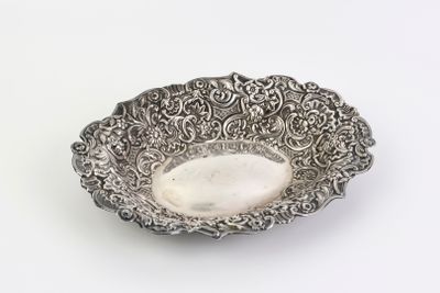 une assiette en argent antique sur fond blanc avec un fond blanc