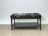 une table basse noire sur laquelle sont posés deux plateaux
