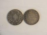 two silver coins, one with a crown and the other with a coat of arms