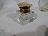 une petite bouteille en verre avec un couvercle en or sur une table
