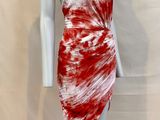 the mannequin is wearing a red and white tie dye dress