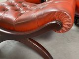a red leather chair and ottoman in a room