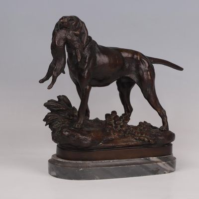 bronze statue of a dog standing on a rock on a marble base