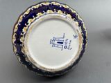 a blue and white vase with a picture of a boat on it