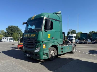 un camion vert garé sur un parking