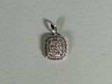 a close up of a small silver pendant on a white surface
