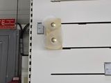 a white refrigerator in the middle of a room next to a trash can